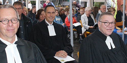 Aktion 5000 Brote Das Bild zeigt Pfarrer Dr. Ralf Stroh, Dekan Steffen Held, Oberkirchenrat Detlev Knoche. Sie sitzen im Talar in der ersten Reihe beim Eröffnungsgottesdienst.