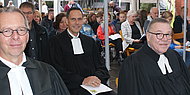 Das Bild zeigt Pfarrer Dr. Ralf Stroh, Dekan Steffen Held, Oberkirchenrat Detlev Knoche. Sie sitzen im Talar in der ersten Reihe beim Eröffnungsgottesdienst.